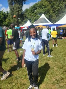 Loise, scholar displays her medal at Alliance Classic Run to support scholarship kitty of Alliance High Sch